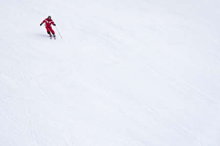 skier riding down the huge snowfield splashing powder snow.のeditorial素材