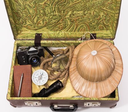 suitcase, camera, travel hat, notebook, map, compass. The concept of preparing for an adventure around the world.の写真素材