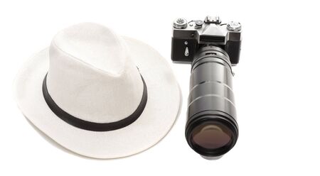 old camera with a large lens and a hat on a white backgroundの写真素材