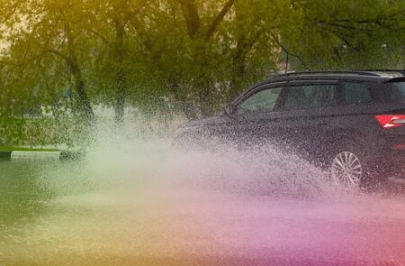 motion car rain big puddle of water spray from the wheelsの写真素材