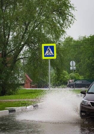 motion car rain big puddle of water spray from the wheelsの写真素材