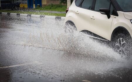 motion car rain big puddle of water spray from the wheelsの写真素材