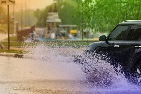 motion car rain big puddle of water spray from the wheelsの写真素材