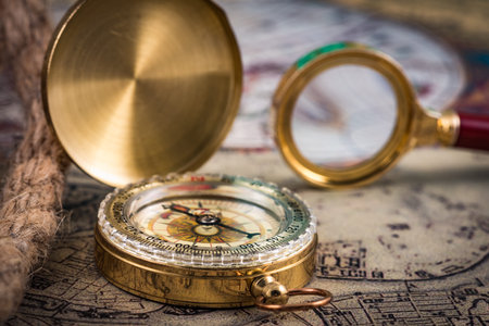 compass and magnifying glass lie on the topographic map