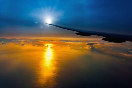 Plane wing and cloud floating on sky through window frame on sunset.  outdoorsの写真素材