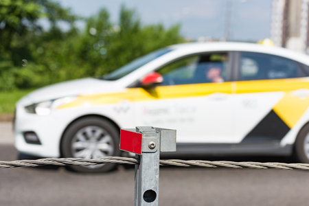 Barrier guard on the road pole with a tensioned cable between the oncoming lanes of the car for...