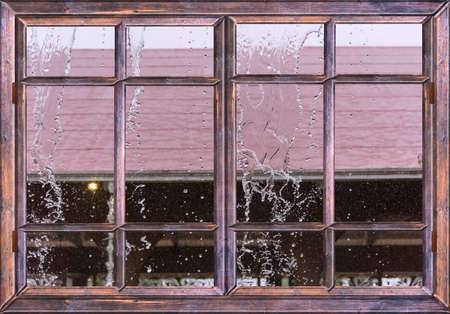 daytime tropical shower from the window of the houseの写真素材