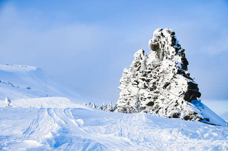 high stone cliff covered with snow in frosty sunny winterの写真素材