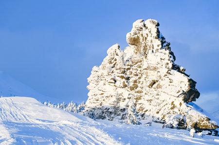 high stone cliff covered with snow in frosty sunny winterの写真素材