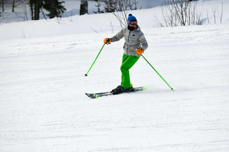 Russia. Sheregesh. 14 February 2021 skier riding down the huge snowfield splashing powder snow.のeditorial素材