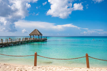wooden gazebo with a roof of palm leaves on a pier in the caribbean seaの写真素材
