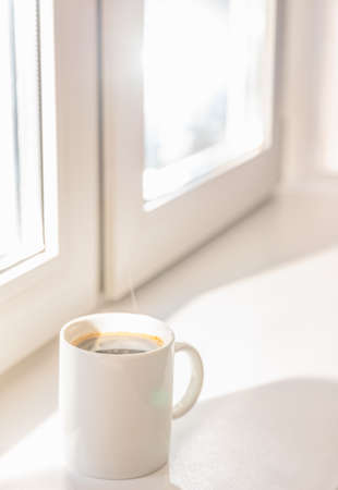 white porcelain coffee cup on the windowsill summer morningの写真素材