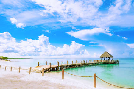 wooden gazebo with a roof of palm leaves on a pier in the caribbean seaの写真素材