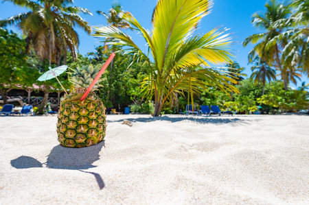 pina colada cocktail in pineapple on the sand of the caribbean beach paradise