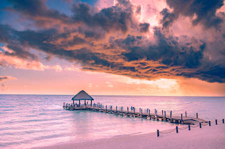 wooden gazebo with a roof of palm leaves on a pier in the caribbean seaの写真素材