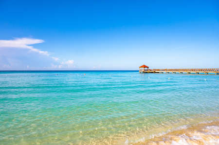 wooden gazebo with a roof of palm leaves on a pier in the caribbean seaの写真素材