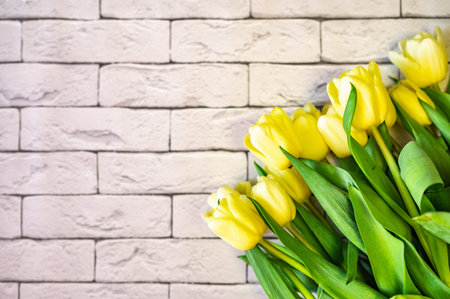 bouquet of yellow tulips on a brick background
