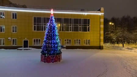 Christmas tree glow lanterns on city square at nightの写真素材