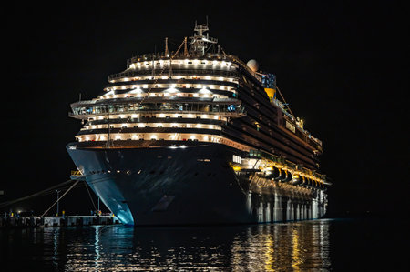 big sea cruise liner at night illuminated by lights in the portの写真素材