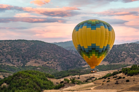 Hot air balloon above high mountain at sunset, filtered backgroundの写真素材