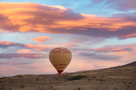 Hot air balloon above high mountain at sunset, filtered backgroundの写真素材