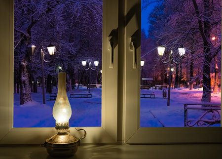 retro kerosene lamp on the windowsill on a winter nightの写真素材