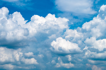 Sunny day with a clear sky adorned by white fluffy clouds offering ample copy space for imagesの写真素材
