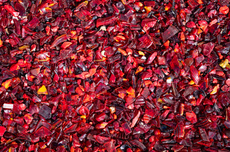 A pile of red chili peppers. The peppers are scattered and broken, creating a jagged and rough surface.の写真素材