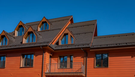 House with a slanted roof and two windows. The windows are on the side of the house, and they are large, allowing for plenty of natural light to enter the home. The roof is made of shinglesの写真素材