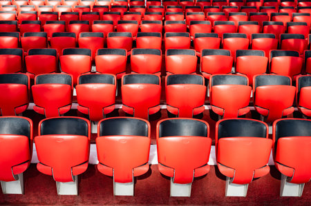 Red seats in an empty auditorium. The quiet and serene atmosphere is enhanced by the orderly...