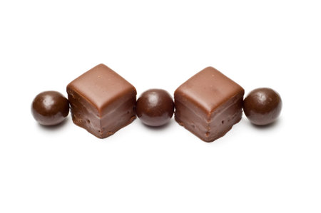 Lined chocolate balls and cubes top view isolated on white