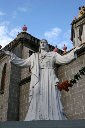 Statue of Jesus in front of churchの写真素材