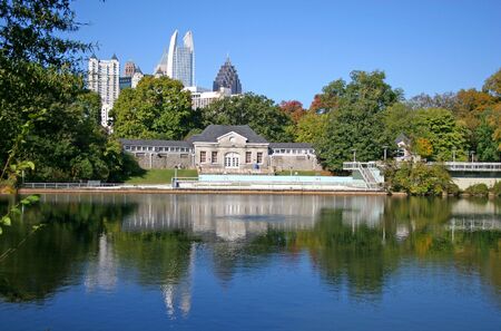 Poolhouse and city skyline across lake in parkの写真素材