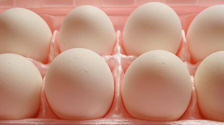 Closeup of White eggs in pink cartonの写真素材