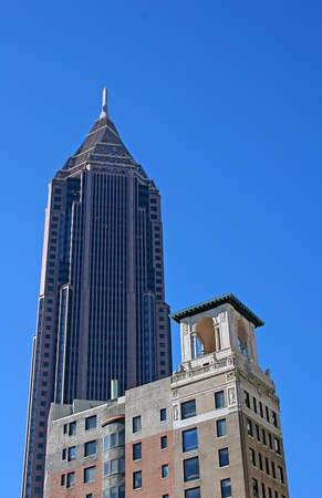 A modern skyscraper with old hotel building in foreground and sky in backgroundの写真素材