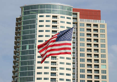 Modern high rise condominium builidng with American flag in foregroundの写真素材