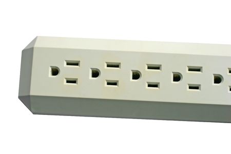 Electrical plugs on surge protector strip isolated on whiteの写真素材