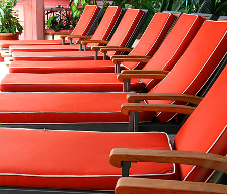 A row of orange chaise lounges in a solariumの写真素材