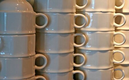 Stacks of white coffee mugs in a restaurantの写真素材