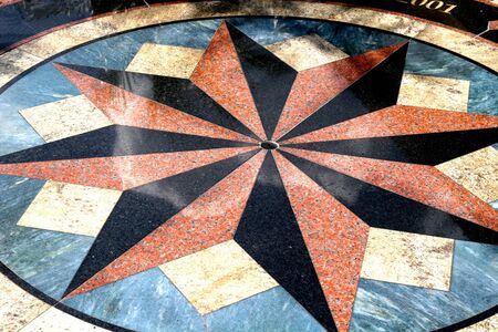 A colorful design on a walkway depicting a compass roseの写真素材