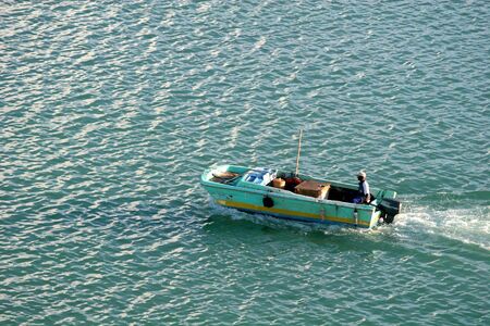 Island fisherman cruising across the bayの写真素材