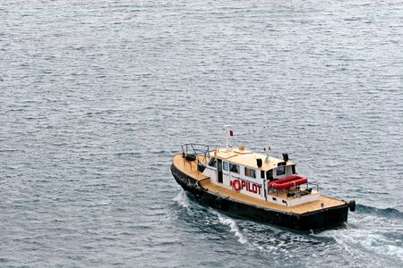 A pilot boat speeding across the harborの写真素材