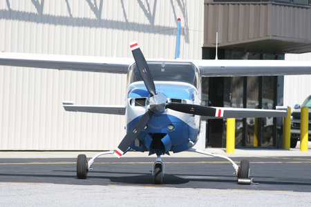 A small blue propeller plane in an airport