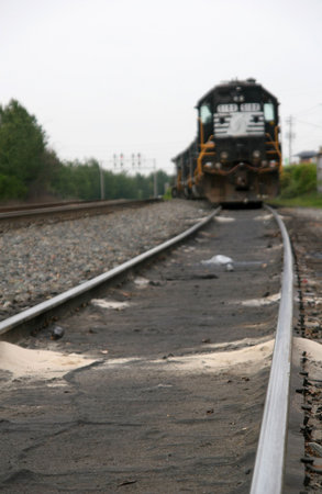 Close up of railroad tracks with locomotive in the background