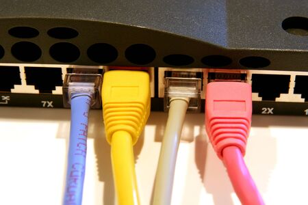Colorful network cables plugged into a routerの写真素材
