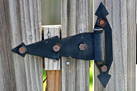 A black wrought iron hinge on an old fenceの写真素材