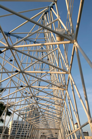 A span of a white steel bridge against blue sky