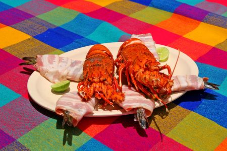 A plate of lobster and seafood on a colorful tableclothの写真素材
