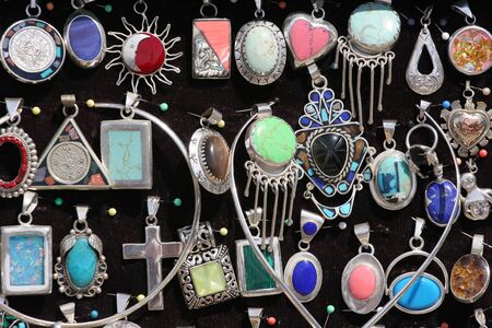 A array of colorful silver pendants at a marketの写真素材