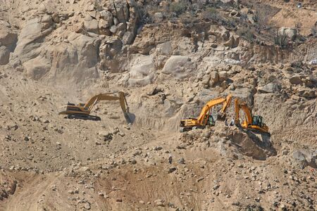 Heavy construction equipment clinging to the face of a steep hillの写真素材